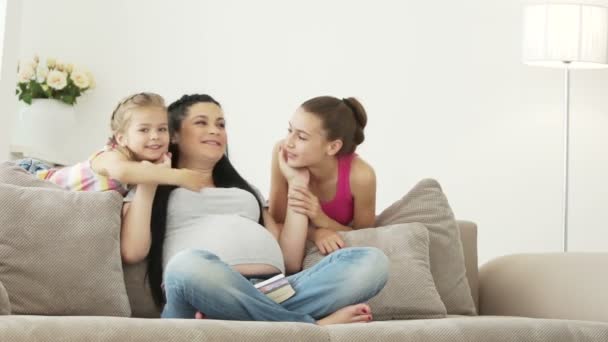 Беременная девушка целует своих дочерей — стоковое видео