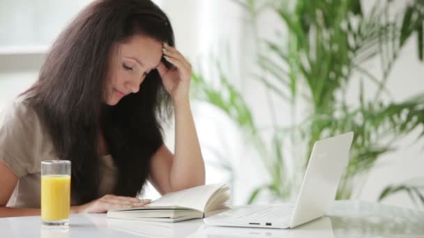 Woman sitting at table reading — Stock Video