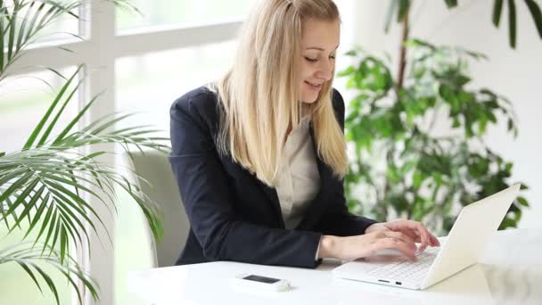 Mujer usando el ordenador portátil y sonriendo — Vídeo de stock