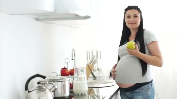 Беременная женщина ест яблоко — стоковое видео