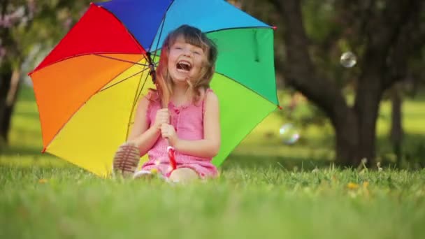 Nettes Mädchen mit Regenschirm sitzen — Stockvideo