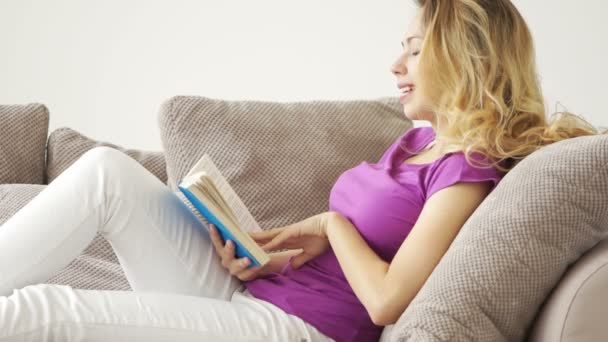 Γυναίκα ξαπλωμένος στο καναπέ ανάγνωση — Αρχείο Βίντεο
