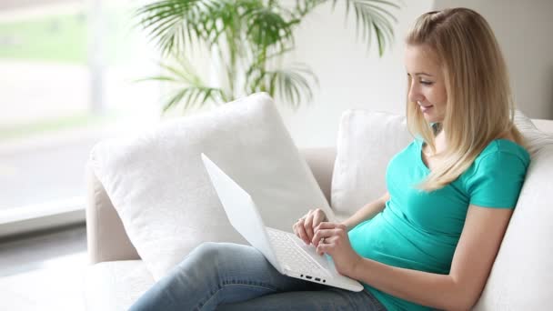 Kvinna som sitter på soffan med laptop — Stockvideo