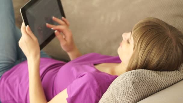 Woman resting on sofa with touchpad — Stock Video