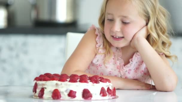 Девушка смотрит на большой торт — стоковое видео
