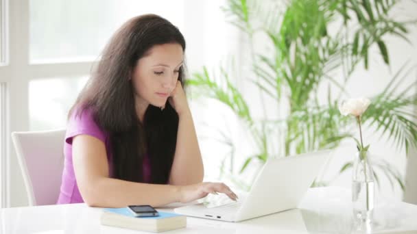 Mujer sentada en la mesa usando portátil — Vídeos de Stock