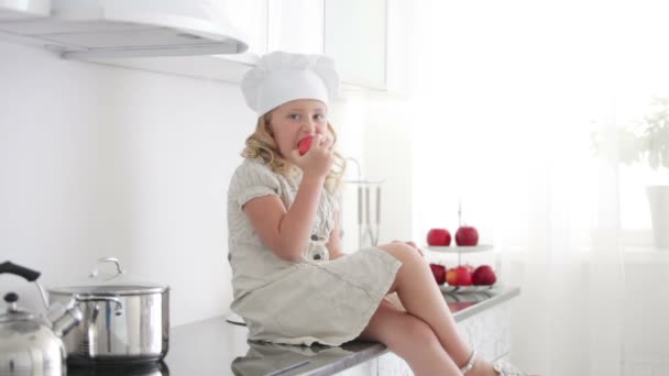 Little girl chef is eating apple — Stock Video