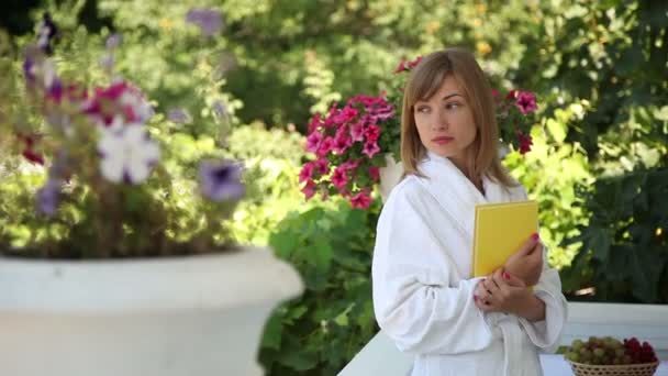 Mujer sosteniendo un libro amarillo — Vídeos de Stock