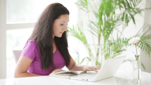 Mulher sentada à mesa usando laptop — Vídeo de Stock