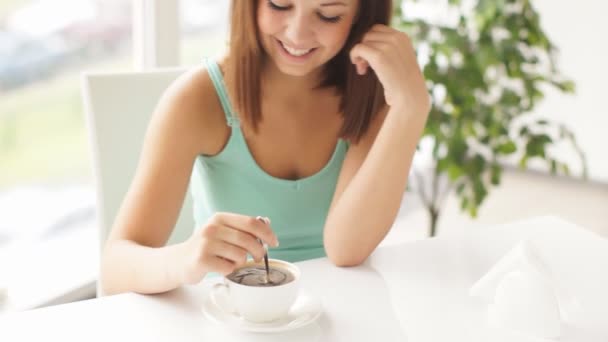 Mulher sentada à mesa mexendo café — Vídeo de Stock