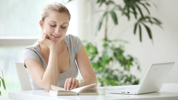 Woman sitting at table reading — Stock Video