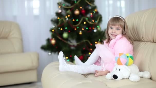 Šťastná holčička sedí na pohovce — Stock video