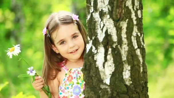 Kleines Mädchen versteckt sich hinter einem Baum — Stockvideo