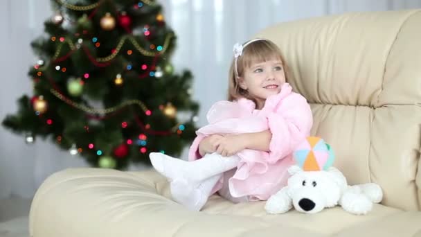 Bir kanepede oturan mutlu küçük kız — Stok video