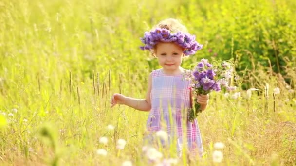 Kind mit violetten Blüten — Stockvideo