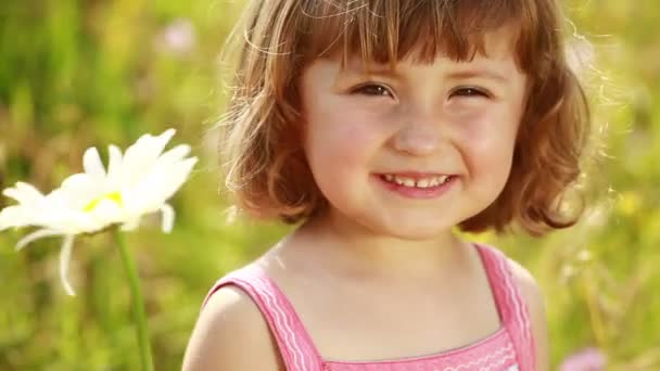 Menina cheirando uma flor de margarida — Vídeo de Stock