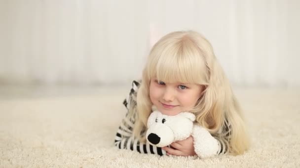 Chica acostada con osito de peluche — Vídeos de Stock