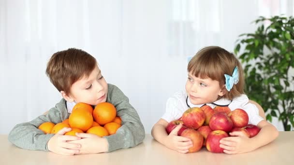 Смеющиеся дети с фруктами за столом — стоковое видео