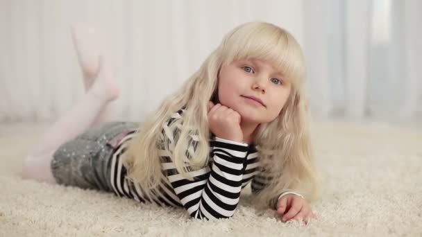 Little girl lying on the carpet. — Stock Video