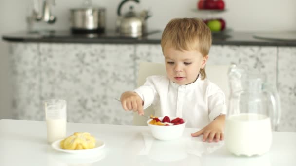 Malý chlapec jíst jogurt jahodový — Stock video