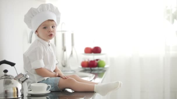 Garçon assis sur la table de cuisine — Video