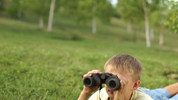 Jongen met een verrekijker liegen — Stockvideo