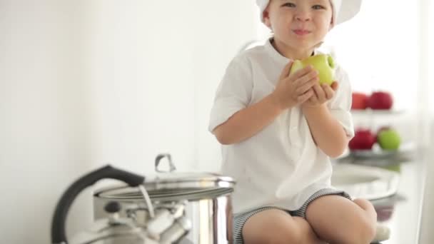 Oy essen Apfel in der Küche — Stockvideo