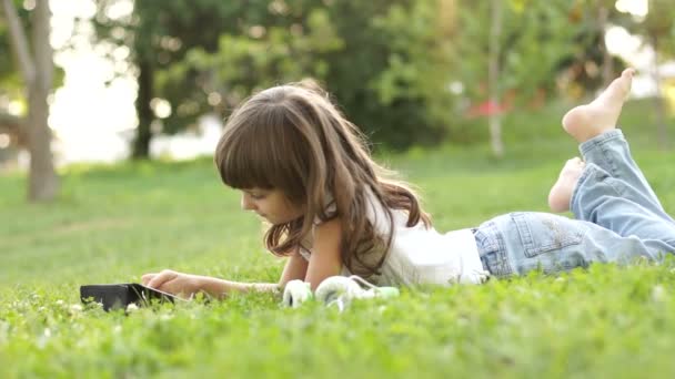 Menina com um tablet pc deitado — Vídeo de Stock