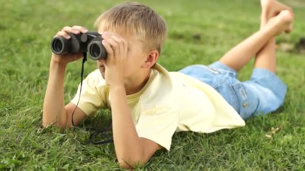 Jongen kijkt door een verrekijker — Stockvideo