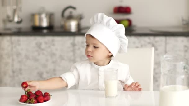 Pequeño cocinero comiendo fresas — Vídeos de Stock