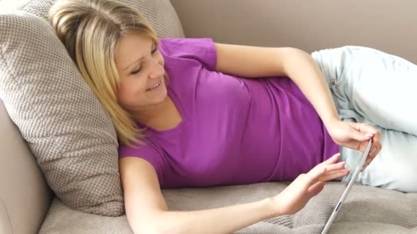 Adolescente deitado no sofá com tablet — Vídeo de Stock
