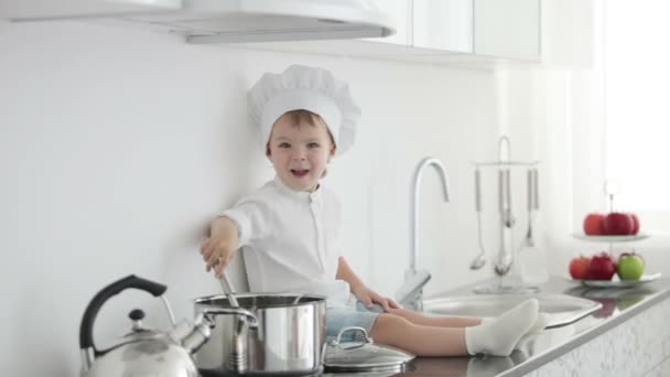 Kleine chef-kok zitten met pollepel — Stockvideo