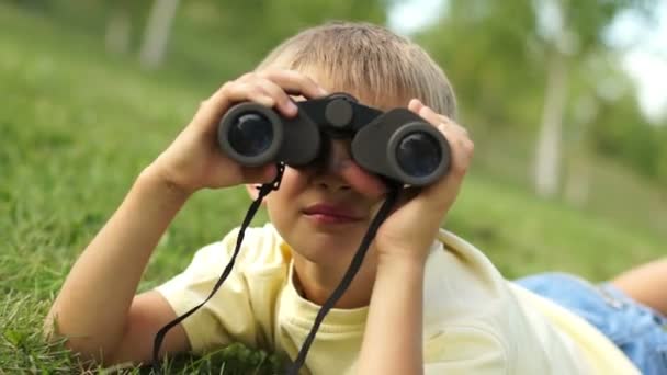 Jongen kijkt door een verrekijker — Stockvideo