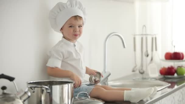 Niño sentado con un cucharón — Vídeos de Stock