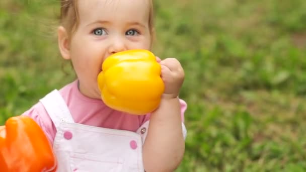 Smiling baby girl with peppers. — Stock Video