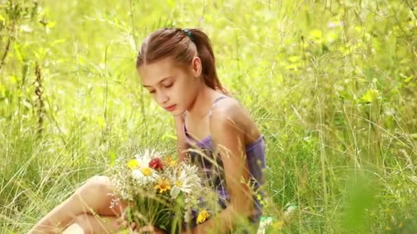 Lány ül a fűben, a virágok — Stock videók