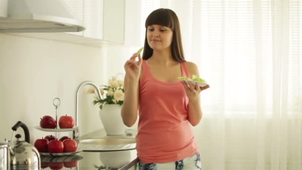 Menina de pé na cozinha comer — Vídeo de Stock