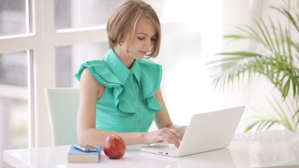 Mädchen sitzt am Schreibtisch mit Laptop — Stockvideo