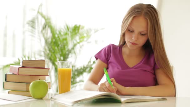 Chica sentada en escritorio escritura — Vídeos de Stock