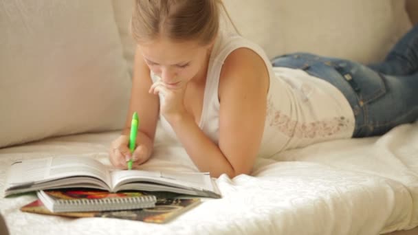 Girl lying on couch writing — Stock Video