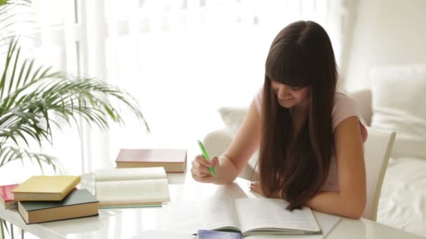 Student meisje studeren aan tafel — Stockvideo