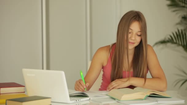 Meisje aan tafel zitten en bestuderen — Stockvideo