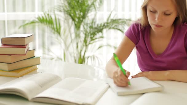 Studentessa seduta a tavola a scrivere — Video Stock
