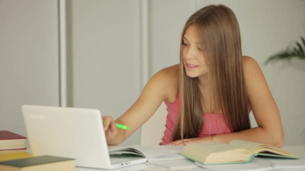 Chica sentada en la mesa y estudiando — Vídeos de Stock