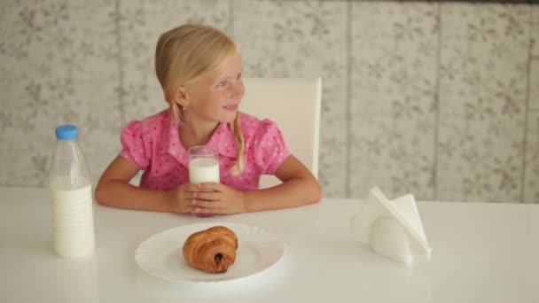 Дівчина сидить за кухонним столом — стокове відео