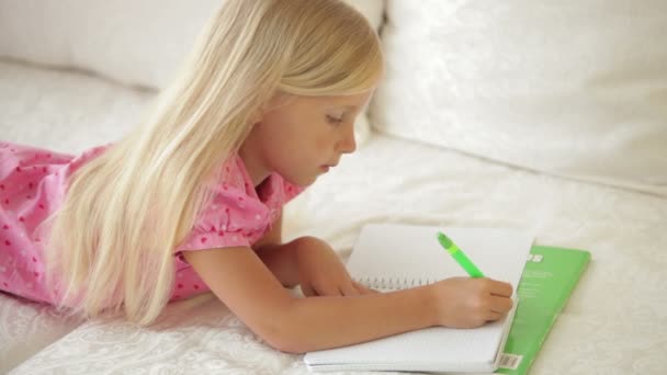 Girl lying on couch and writing — Stock Video