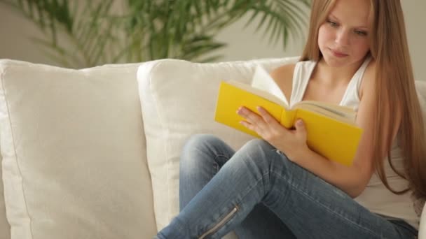 Menina encantadora relaxante no sofá leitura — Vídeo de Stock