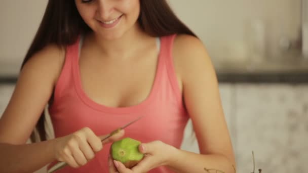 Девушка чистит фрукты киви . — стоковое видео