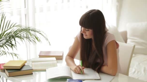 Cute girl sitting at table studying — Stock Video