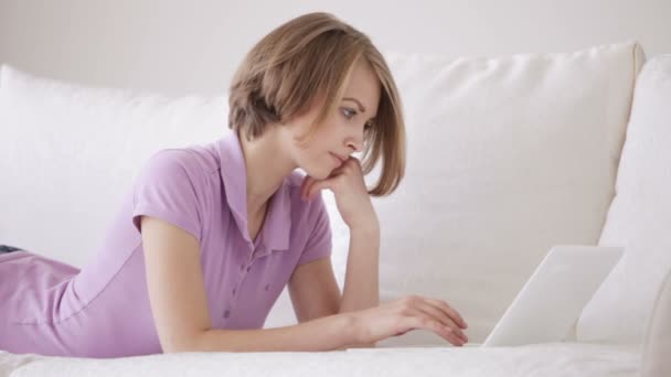 Lány bágyasztó-on dívány használ laptop — Stock videók